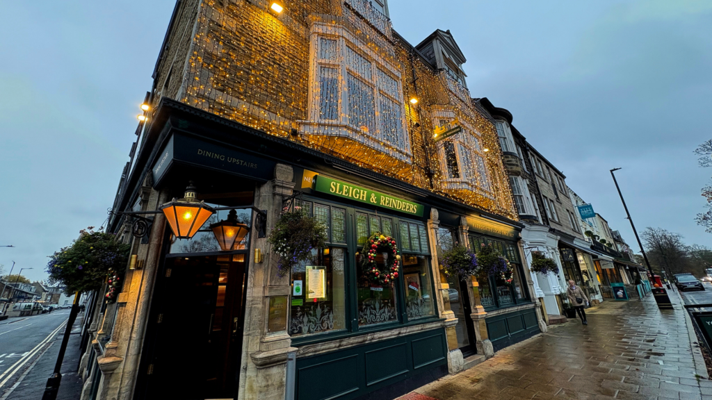 Exterior shot of The Sleigh and Reindeers pub in Harrogate, covered in Christmas wreaths and gold fairy lights.